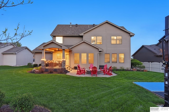rear view of property featuring a patio and a fire pit