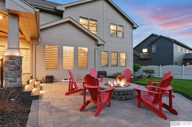 patio terrace at dusk with a fire pit and fence
