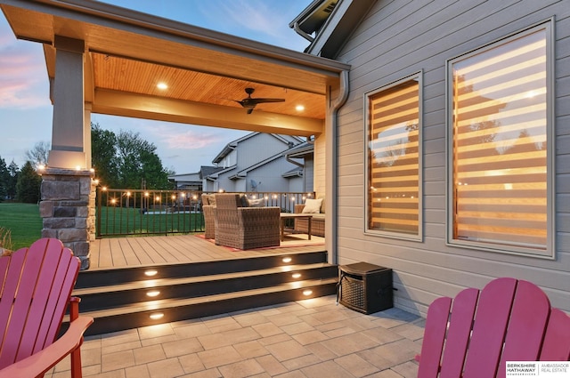 deck at dusk with a ceiling fan and a patio