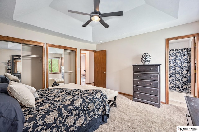 14523 Parker St, Omaha, NE 68154 - carpeted bedroom with a tray ceiling, multiple closets, ceiling fan, and baseboards