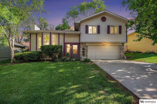 14523 Parker St, Omaha, NE 68154 - split level home with a garage, driveway, a yard, and a chimney