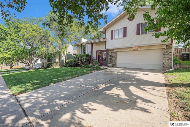 14523 Parker St, Omaha, NE 68154 - split level home featuring an attached garage, driveway, a front lawn, a chimney, and brick siding