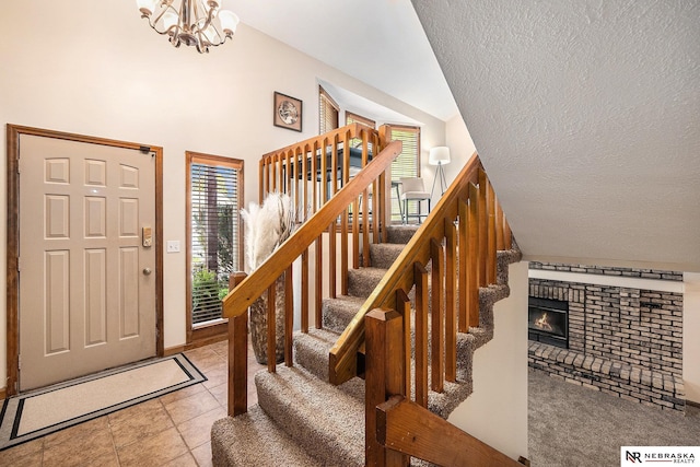 14523 Parker St, Omaha, NE 68154 - entryway with stairway, a textured ceiling, a fireplace, a chandelier, and baseboards