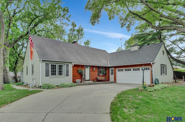 view of front of home featuring an attached garage, driveway, a chimney, a front lawn, and brick siding