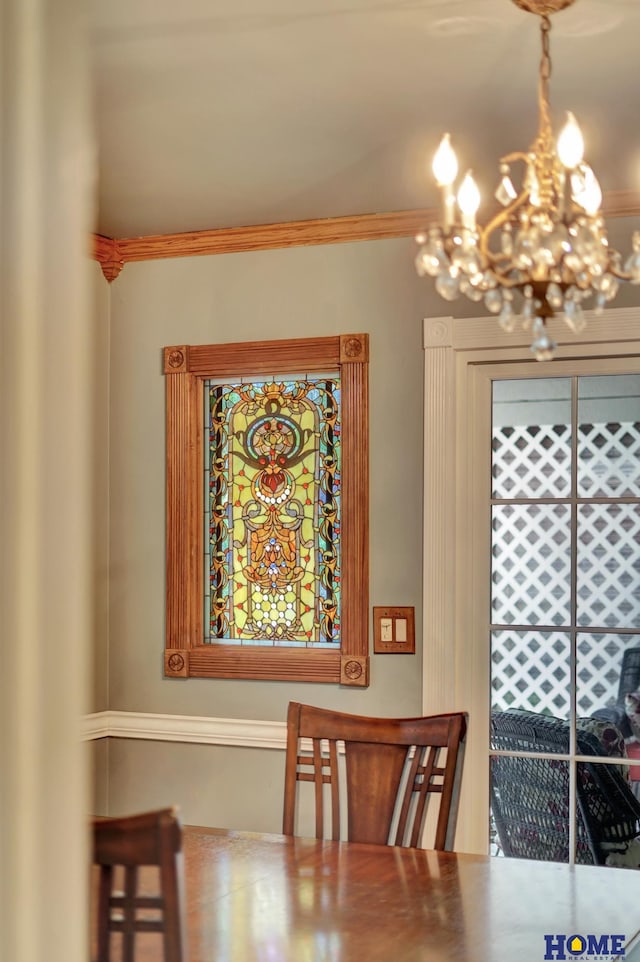 dining area featuring a chandelier and crown molding