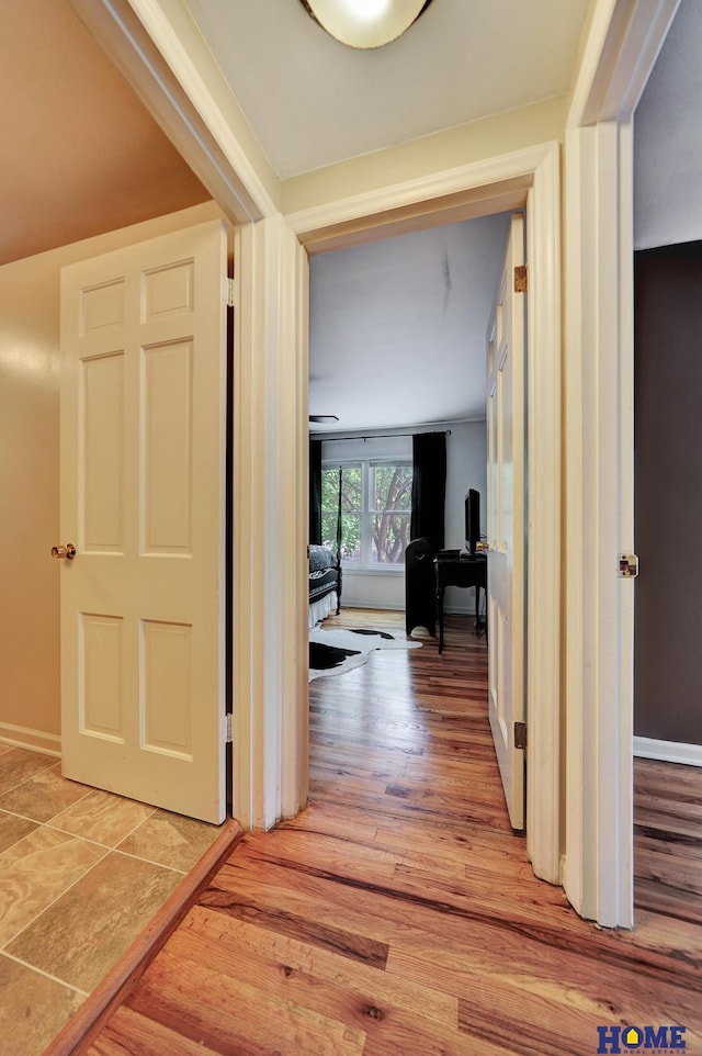 hall featuring light wood finished floors and baseboards