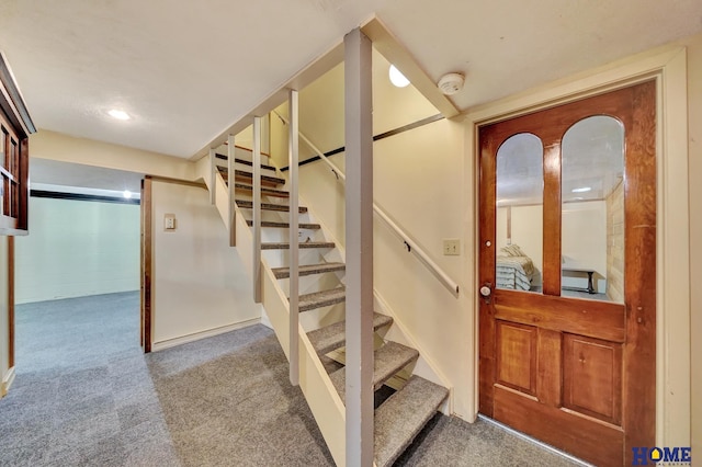 staircase featuring carpet