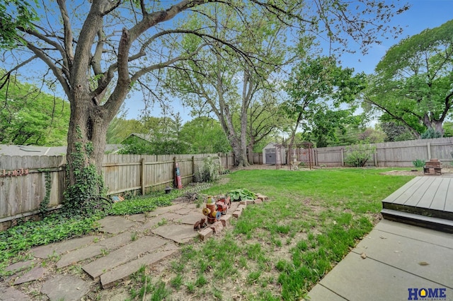 view of yard featuring a storage shed, an outbuilding, and a wooden deck