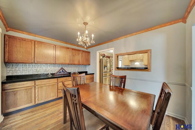 dining room featuring a chandelier, ornamental molding, and light wood finished floors