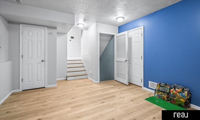 11019 Weber St, Omaha, NE 68142 - finished below grade area with a textured ceiling, wood finished floors, baseboards, and stairway