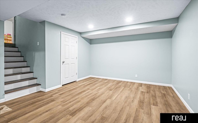 11019 Weber St, Omaha, NE 68142 - finished below grade area with wood finished floors, stairs, baseboards, a textured ceiling, and recessed lighting