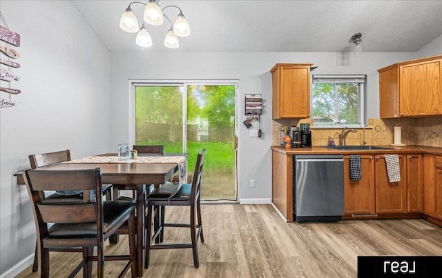11019 Weber St, Omaha, NE 68142 - kitchen with dishwasher, a sink, light wood finished floors, a chandelier, and backsplash