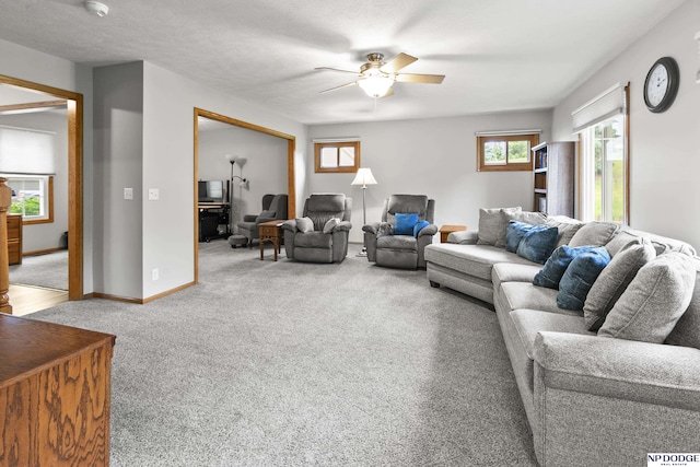 carpeted living room with ceiling fan and baseboards