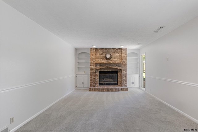 unfurnished living room featuring a fireplace, built in shelves, baseboards, and carpet floors