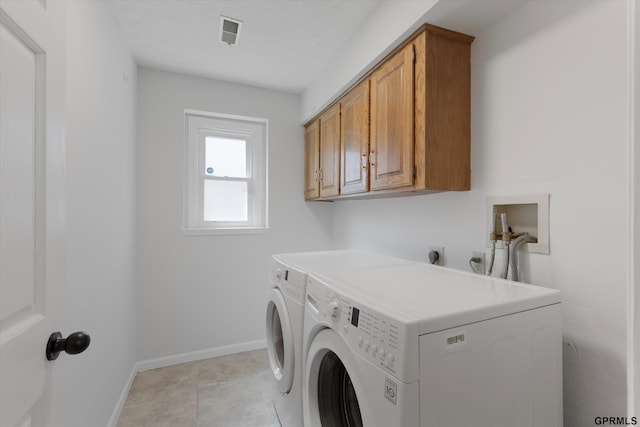 clothes washing area with cabinet space, independent washer and dryer, and baseboards
