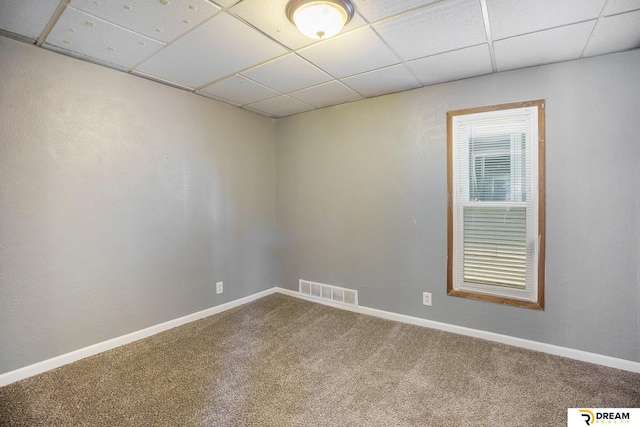 unfurnished room featuring carpet floors, a paneled ceiling, and baseboards