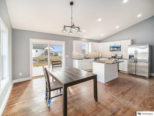 5910 SW 9th St, Lincoln, NE 68523 - kitchen with appliances with stainless steel finishes, lofted ceiling, a center island, decorative backsplash, and a sink