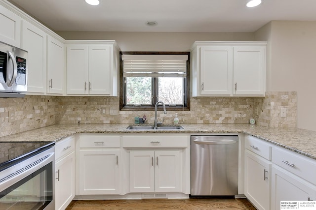 8114 S 167th St, Omaha, NE 68136 - kitchen featuring appliances with stainless steel finishes, white cabinetry, tasteful backsplash, and recessed lighting