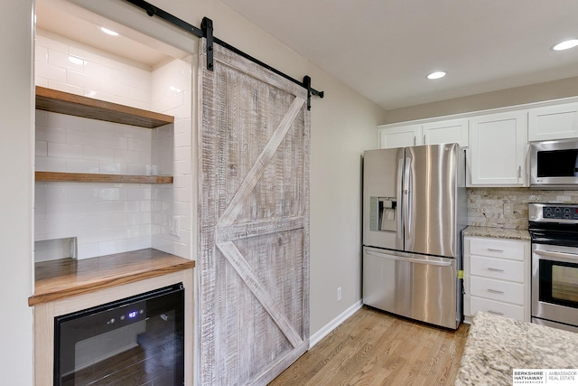 8114 S 167th St, Omaha, NE 68136 - kitchen with appliances with stainless steel finishes, a barn door, wine cooler, white cabinetry, and recessed lighting