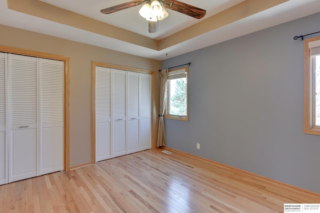 8114 S 167th St, Omaha, NE 68136 - unfurnished bedroom with light wood-style flooring, two closets, and a tray ceiling