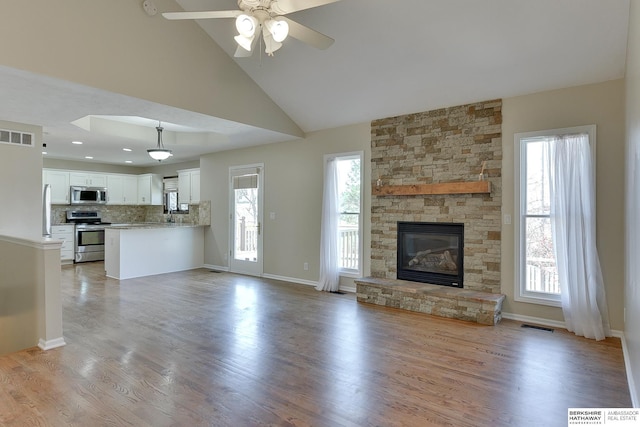 8114 S 167th St, Omaha, NE 68136 - unfurnished living room with ceiling fan, light wood finished floors, a fireplace, and high vaulted ceiling