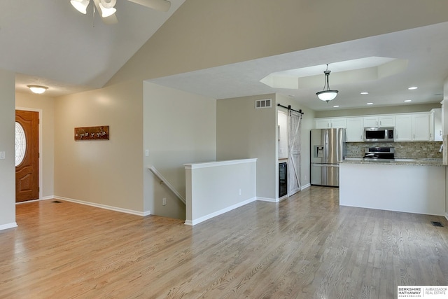 8114 S 167th St, Omaha, NE 68136 - unfurnished living room with a barn door, light wood-style floors, ceiling fan, recessed lighting, and lofted ceiling