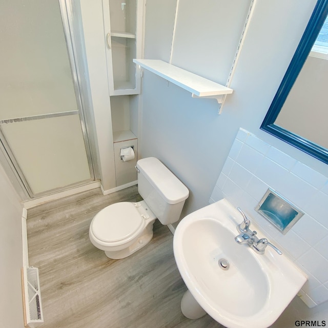 101 E 28th Ave, Bellevue, NE 68005 - bathroom featuring a sink, a shower stall, wood finished floors, and toilet