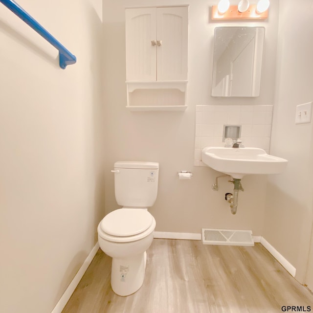 101 E 28th Ave, Bellevue, NE 68005 - half bathroom with wood finished floors, baseboards, toilet, and decorative backsplash