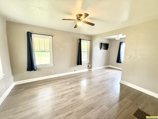 empty room featuring ceiling fan, wood finished floors, and baseboards