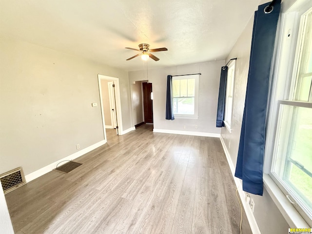unfurnished living room featuring ceiling fan, baseboards, and light wood finished floors