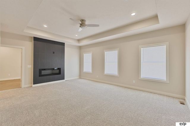 513 13th Ave, Plattsmouth, NE 68048 - unfurnished living room featuring a tray ceiling, carpet, ceiling fan, baseboards, and recessed lighting