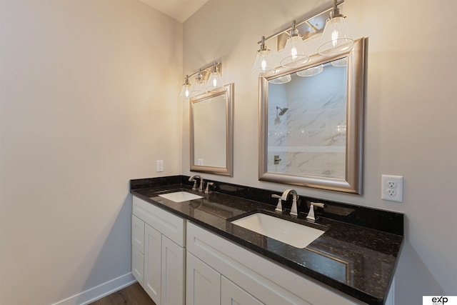 513 13th Ave, Plattsmouth, NE 68048 - bathroom featuring a shower, double vanity, baseboards, and wood finished floors