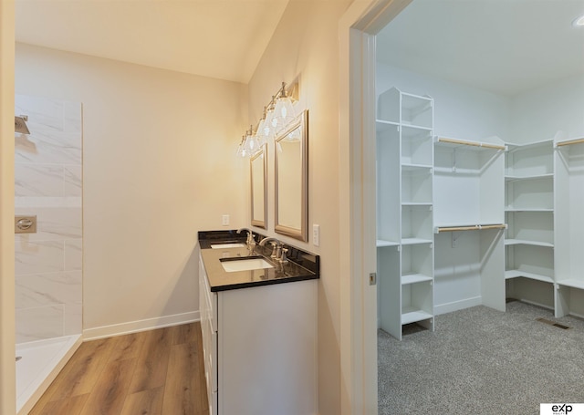 513 13th Ave, Plattsmouth, NE 68048 - full bath featuring a walk in closet, baseboards, double vanity, tiled shower, and wood finished floors