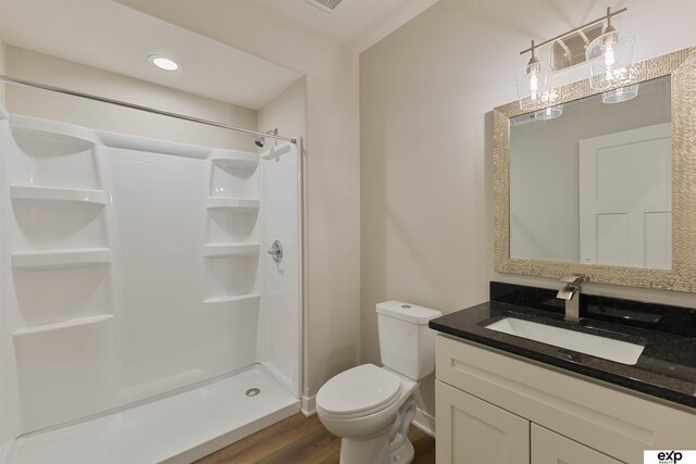 513 13th Ave, Plattsmouth, NE 68048 - full bathroom with wood finished floors, a stall shower, toilet, and vanity
