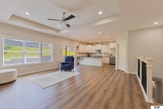 513 13th Ave, Plattsmouth, NE 68048 - living area featuring a raised ceiling, light wood-style flooring, ceiling fan, recessed lighting, and baseboards