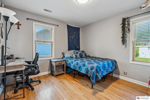 bedroom featuring wood finished floors, baseboards, and a desk