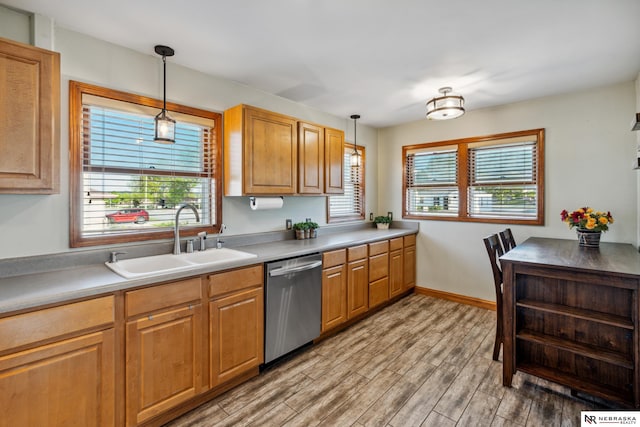kitchen with stainless steel dishwasher, a sink, plenty of natural light, and light wood finished floors