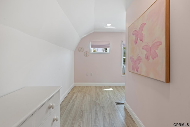 bonus room featuring lofted ceiling, light wood-type flooring, and baseboards