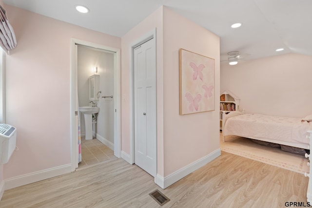 bedroom featuring light wood-style flooring, recessed lighting, baseboards, and ensuite bathroom