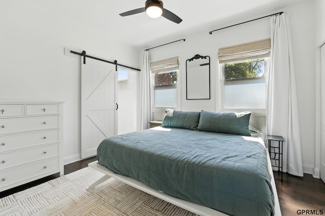 bedroom featuring a barn door and dark wood-style floors