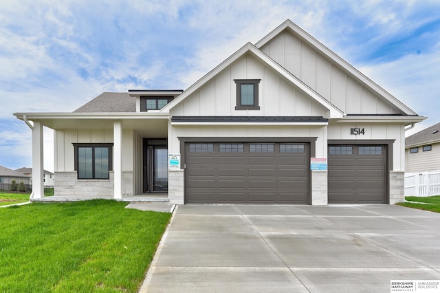 view of front facade featuring board and batten siding, driveway, and a front yard