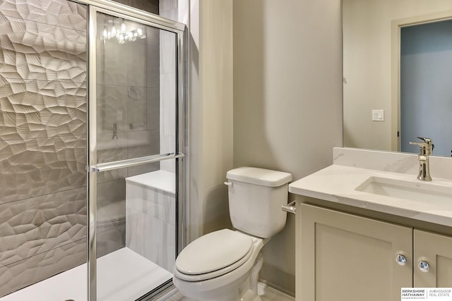 bathroom featuring a stall shower, toilet, and vanity
