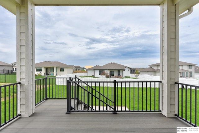 wooden terrace with a residential view and a yard
