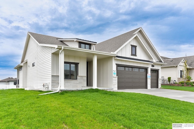 view of front of house with board and batten siding, driveway, a front lawn, and a shingled roof