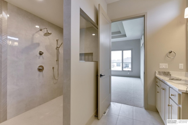 bathroom with a walk in shower, tile patterned floors, vanity, and baseboards