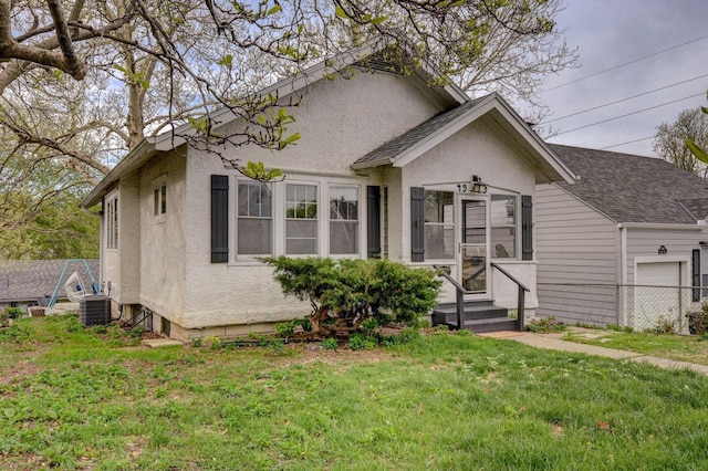 4939 Hickory St, Omaha, NE 68106 - bungalow-style house with a front lawn, stucco siding, an attached garage, and central AC unit