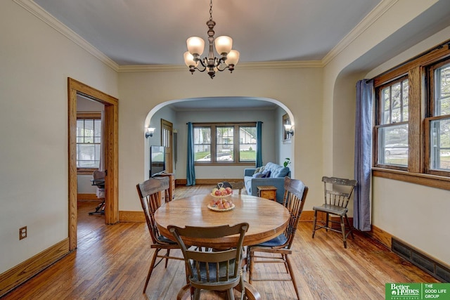 4939 Hickory St, Omaha, NE 68106 - dining room with arched walkways, plenty of natural light, a chandelier, and crown molding