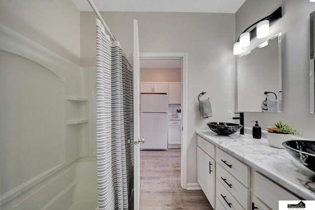 927 Garfield St, Lincoln, NE 68502 - full bathroom with wood finished floors, a shower with shower curtain, and double vanity