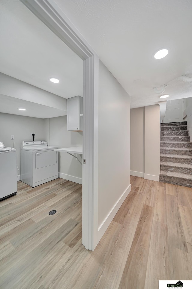 927 Garfield St, Lincoln, NE 68502 - finished below grade area with washing machine and dryer, stairs, light wood-style floors, and baseboards