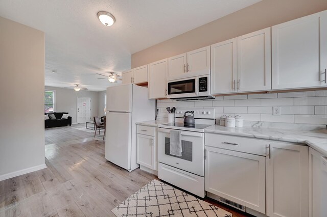 927 Garfield St, Lincoln, NE 68502 - kitchen featuring white appliances, white cabinets, ceiling fan, and decorative backsplash